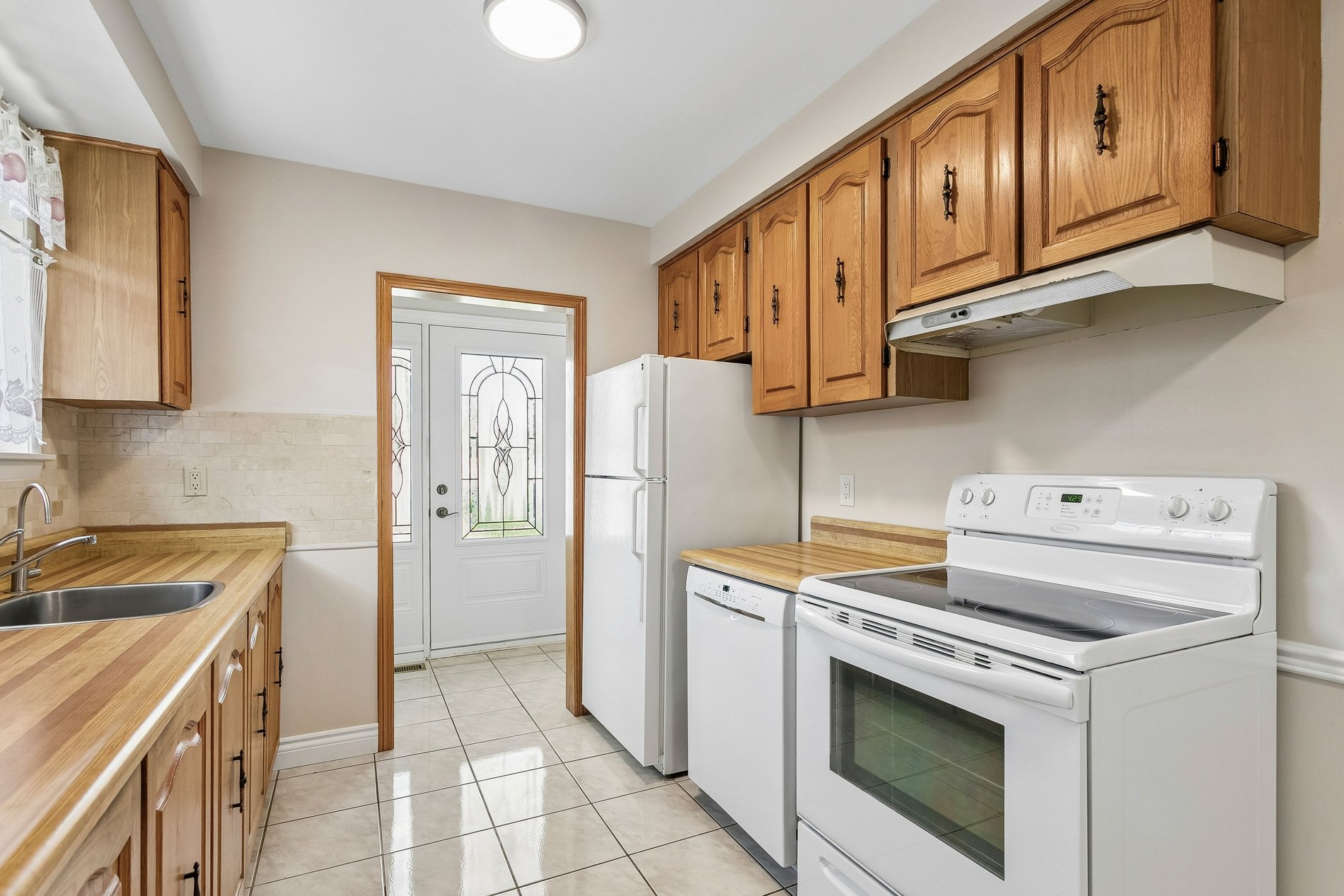 Traditional kitchen with oak cabinets and white appliances