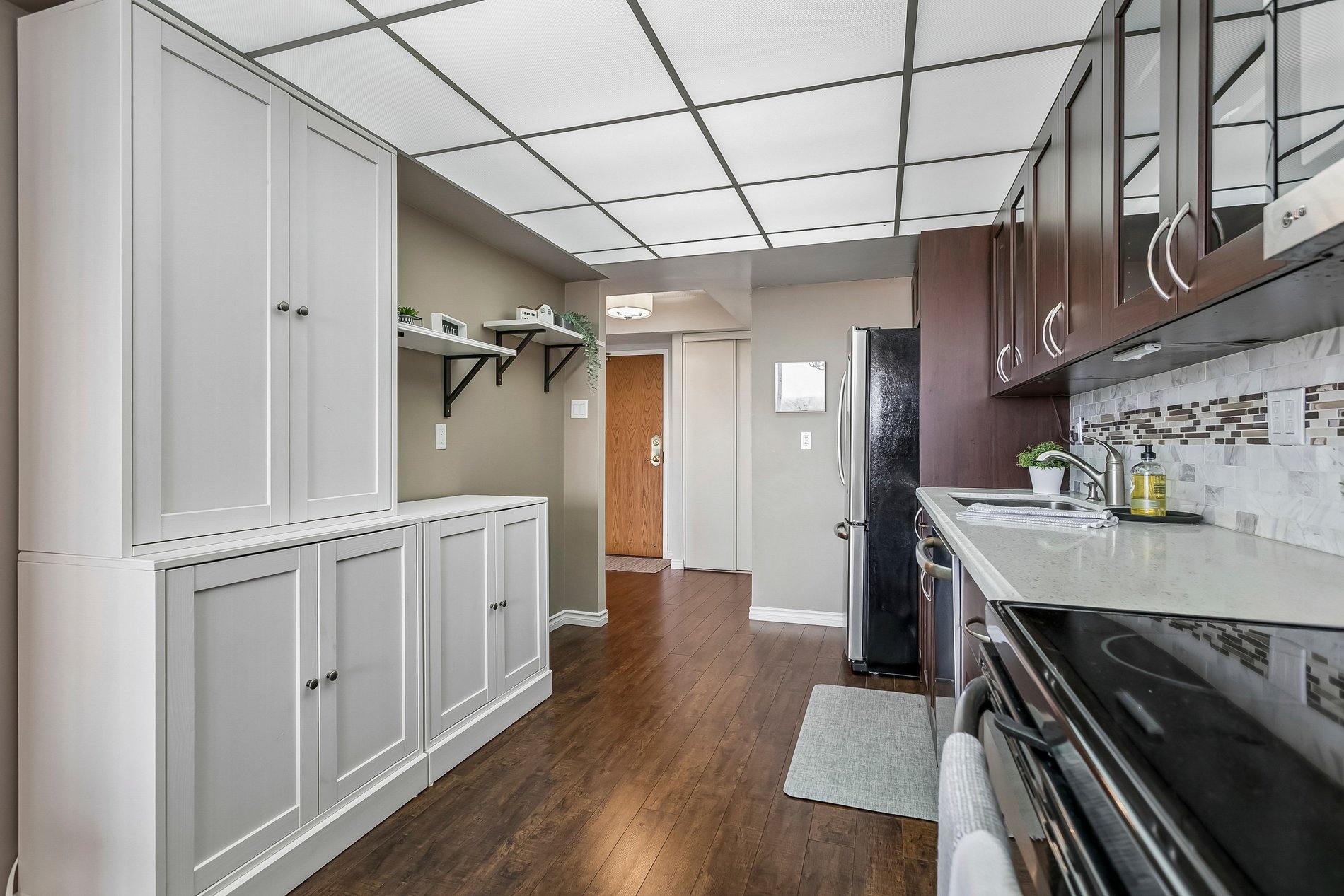 Modern galley kitchen with dark cabinets and built-in storage