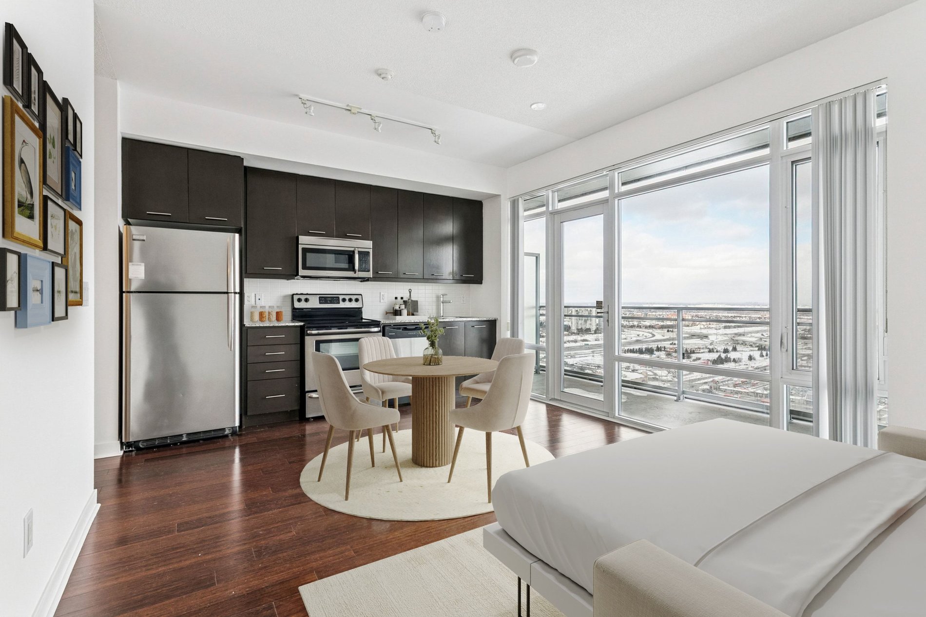 Modern studio condo with kitchen, dining area, and large windows