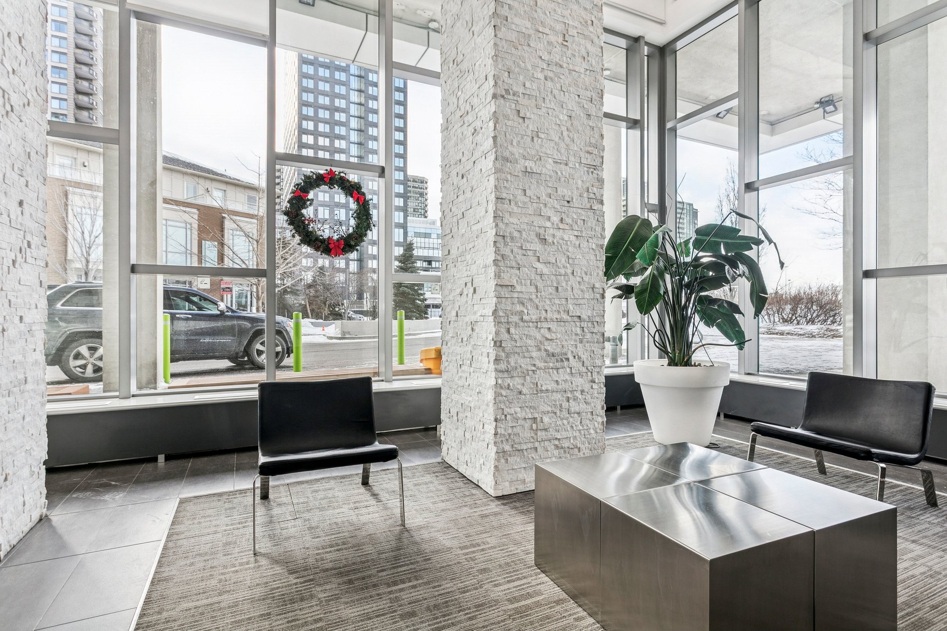 Contemporary condo lobby with seating and large windows