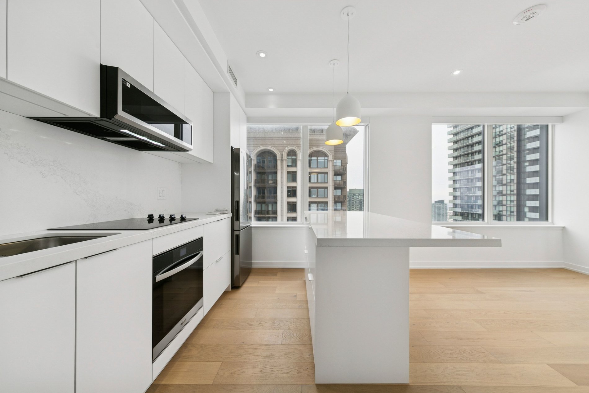Modern white kitchen with island and floor-to-ceiling windows