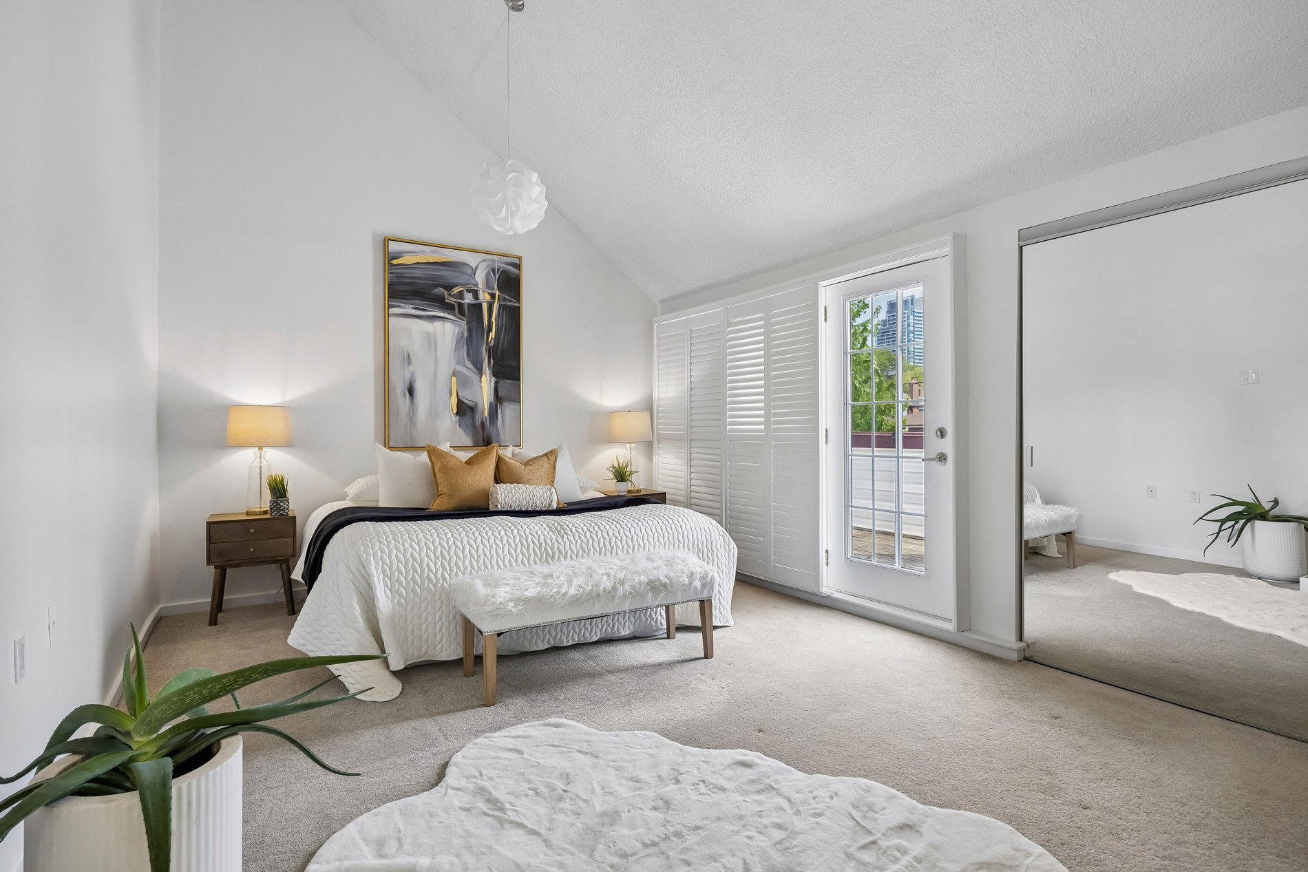 Bright primary bedroom with balcony access and mirrored closet doors