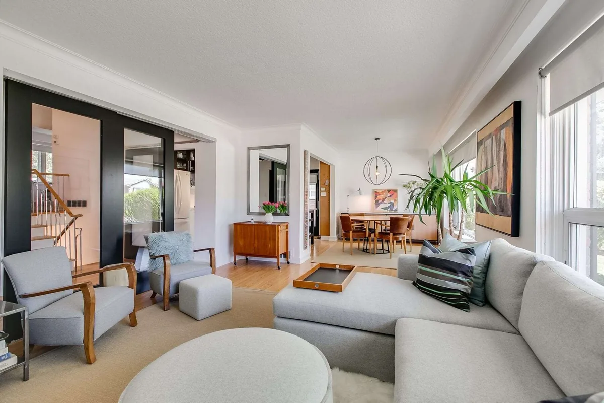 Modern Toronto condo living room with floor to ceiling windows framing the CN Tower and downtown skyline